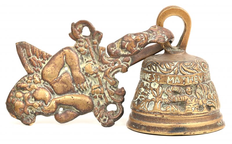 Een bronzen bel met muurbevestiging.