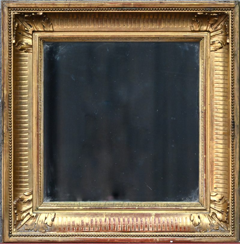 Een antieke vierkante spiegel in vergulde lijst.