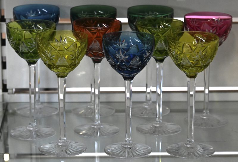 Een reeks van tien geslepen kristallen glazen met gekleurde kelken. Hier en daar zeer lichte gebruikssporen.