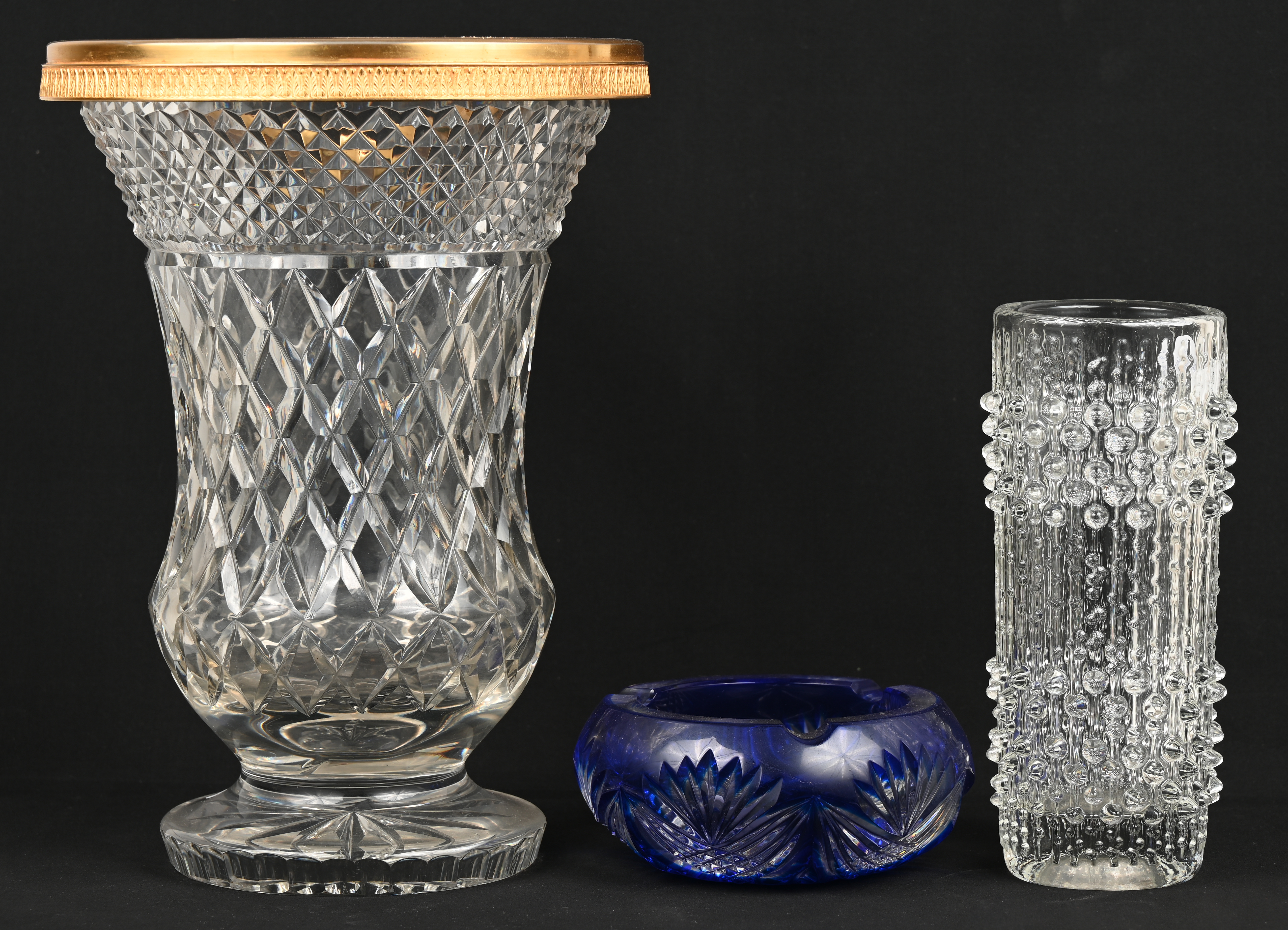 stuks kristal en glaswerk, bestaande uit een kleurloze vaas piedouche (randschade), een Italiaans glazen vaas en een asbak van geslepen blauw Boheems kristal. – Jordaens N.V. Veilinghuis