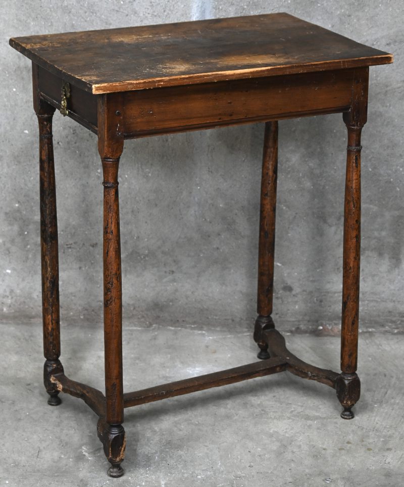 Een rustiek antiek houten tafeltje met één lade.
