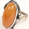 Een zilveren ring met bijpassende armband en ketting met hanger bezet met amber. 925‰.