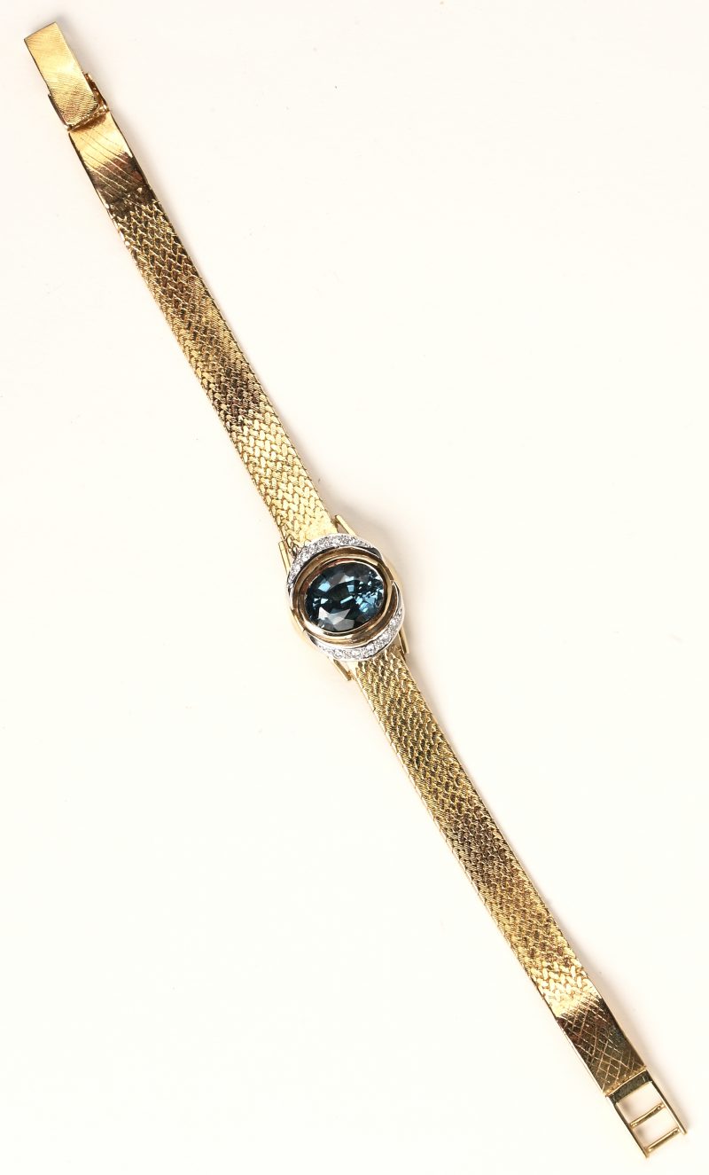 Een 18 K geelgouden armband bezet met briljanten met een gezamenlijk gewicht van +- 0,10 ct. en een tourmalijn gezet in horlogekast van +- 4 ct.