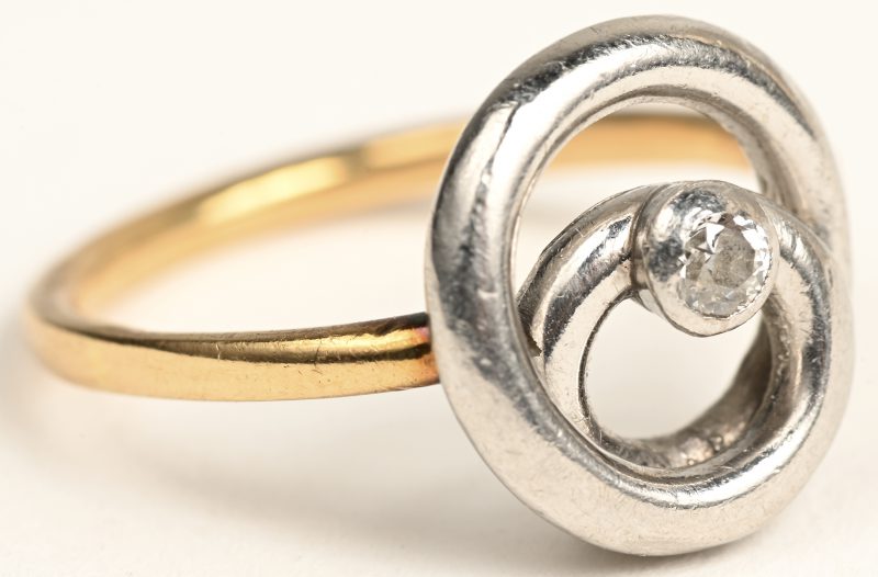 Een 18 K geelgouden en platina ring bezet met één briljant van +- 0,10 ct.
