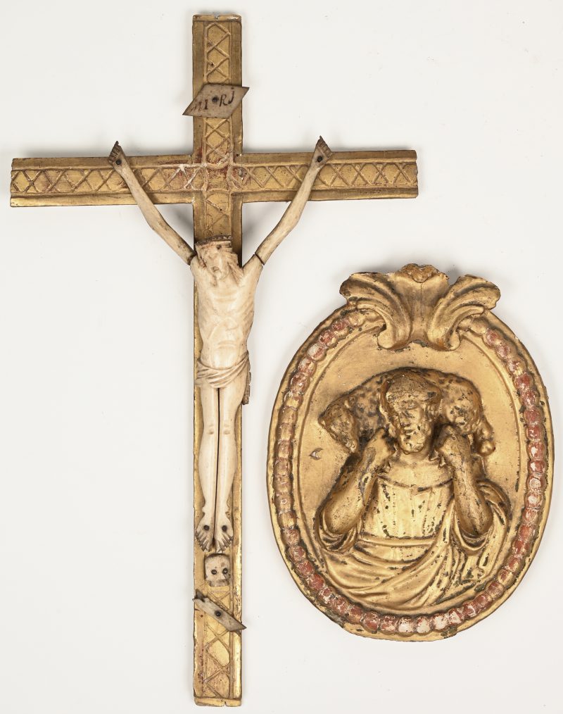 Twee snijwerkjes, bestaande uit een prilitieve Christus van been en een verguld houten medaillon met voorstelling van een Heilige.