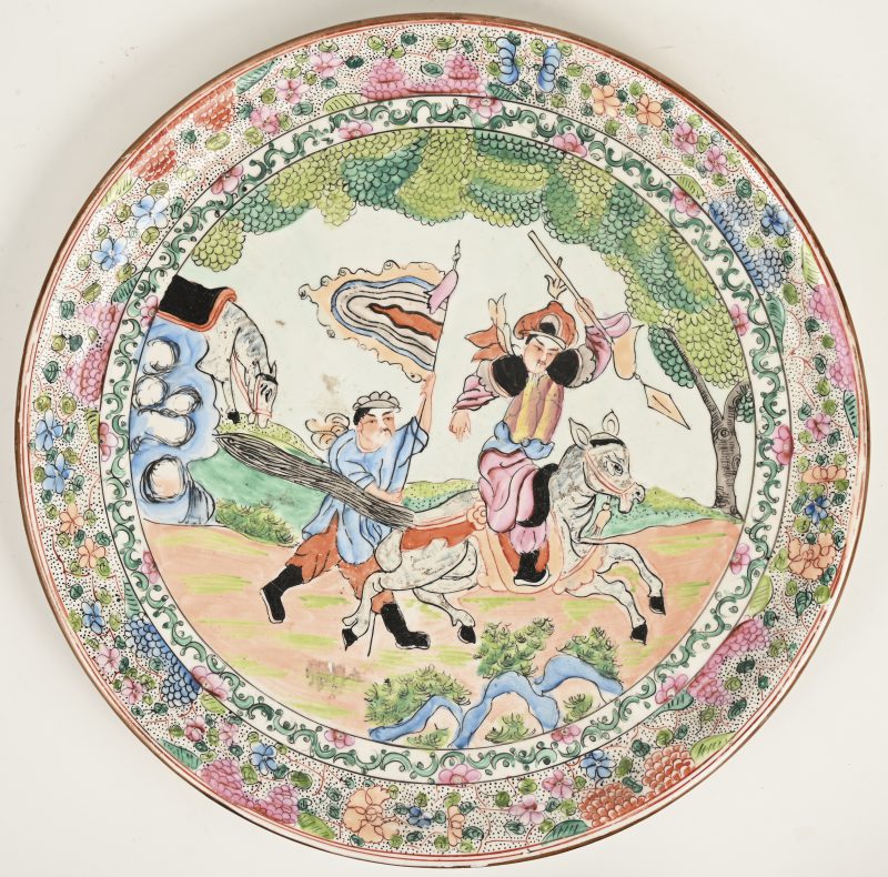 Een grote schotel van Chinees aardewerk met een Europees decor van jagers.