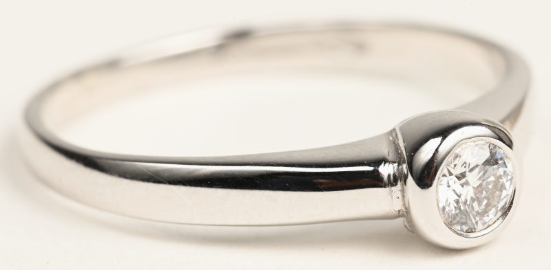 Een 18 K witgouden ring bezet met één briljant van +- 0,20 ct.