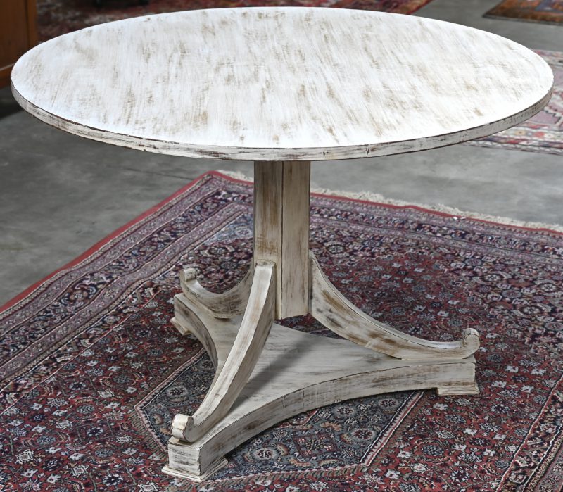 Een grijsgepatineerde ronde tafel met opklapbaar blad.