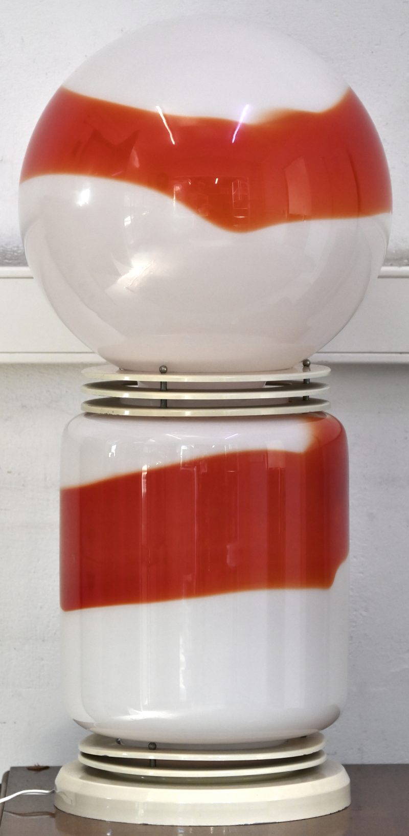 Een vintage designlamp met basis en bol van oranje en wit Muranoglas. In de stijl van Mazzega door Carlo Mason.