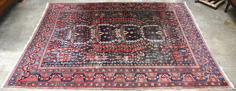 Een antiek handgeknoopt Perzisch wollen tapijt.