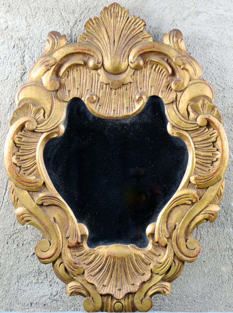 Een verguld houten spiegeltje in barokke stijl.