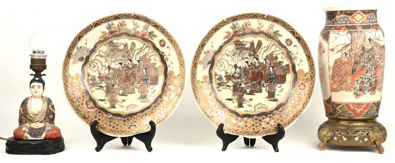 Een lot Japans aardewerk, bestaande uit twee sierschotels, een vaas en een lampvoetje met Boeddha.