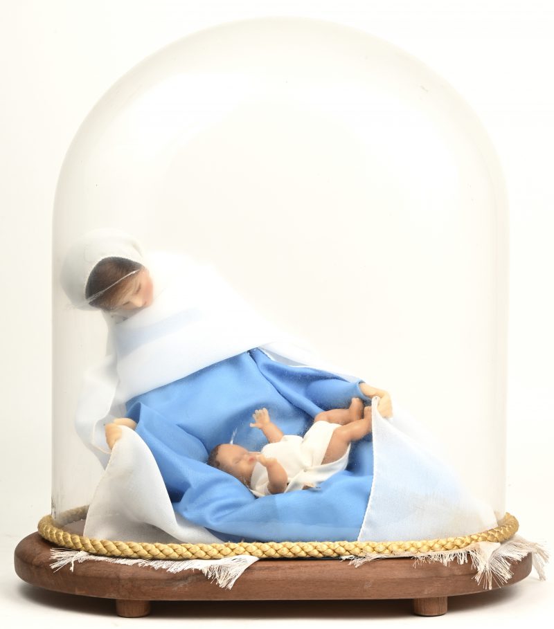 “Maria met kind”. Een wassen beeld onder een glazen stolp.