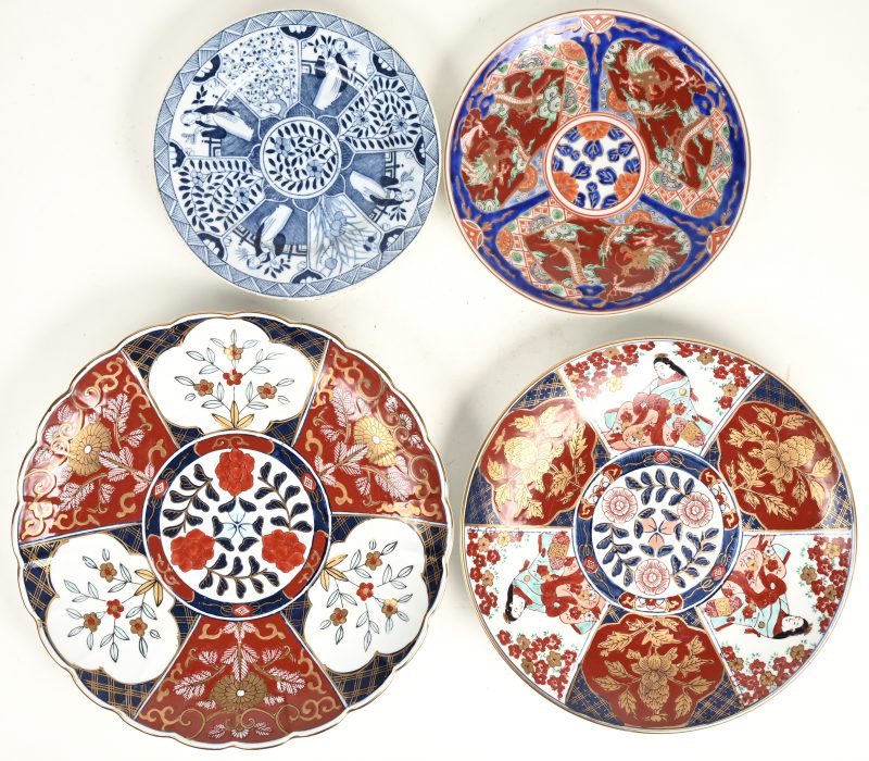 Een lot van vier porseleinen borden, waarbij één blauw-wit en twee van Goldimari gemerkt.