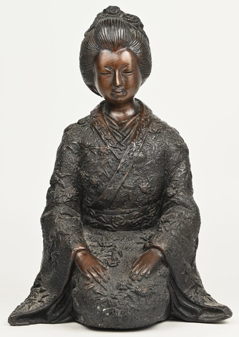 Een geknielde geisha van gepatineerd brons.