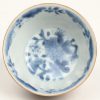 Een kopje en schoteltje van Chinees porselein met blauw op witte decors en met capucineglazuur aan de buitenkanten.