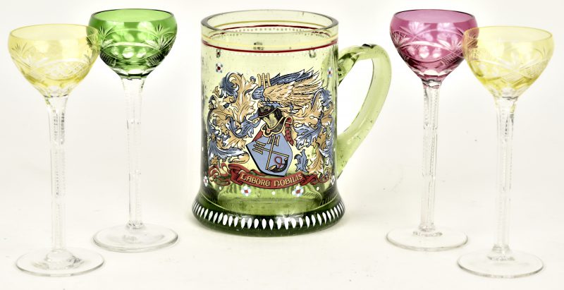 Een glazen bierpul met verguld decor met wapenschild “Labore Nobilis” en vier kleine kristallen glaasjes met gekleurde kelkjes.