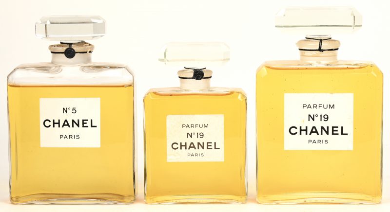 Drie factices van Chanel, waarbij één No.5 en een grote en een kleien No.19.