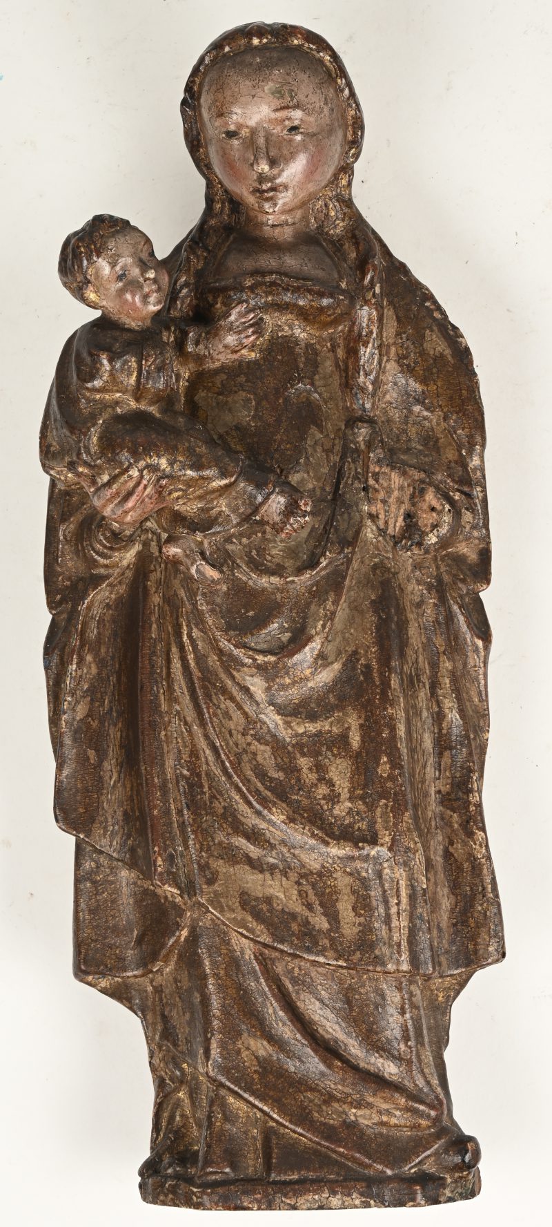 Een Madonna met Kind van gebeeldhouwd hout met sporen van de oorspronkelijke polychromie. Mooi patina, kleine manco’s. Vlaanderen, omstreeks 1600.