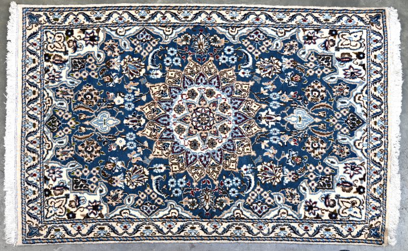 Een handgeknoopt Perzisch tapijtje van wol en zijde.