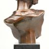 Een vrouwenbuste van bruingepatineerd brons op arduinen sokkel naar een werk van Léonildo Giannini. Gesigneerd.