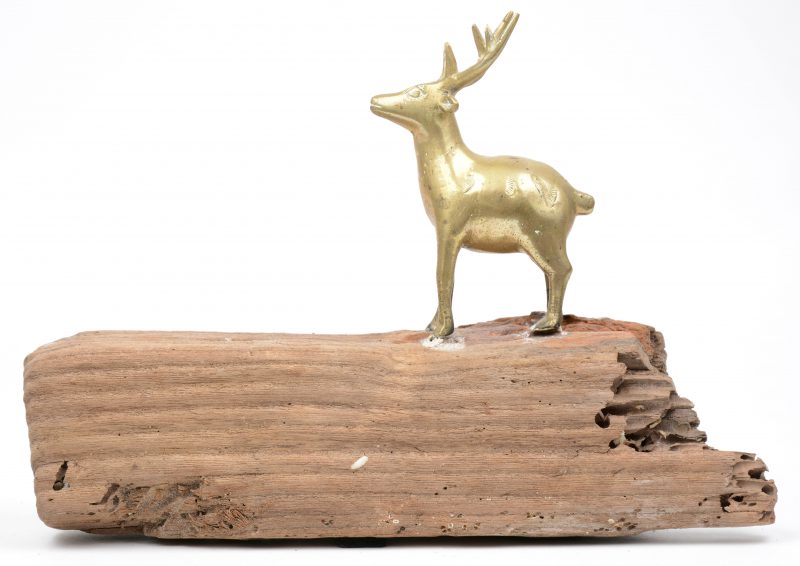 Een koperen beeldje in de vorm van een hert, bevestigd op een stuk wrakhout. Sri Lanka.