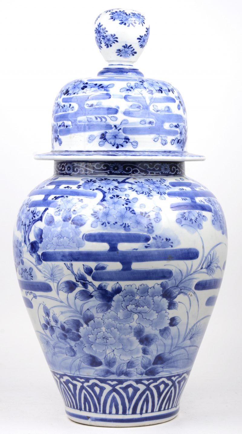 Een Chinees porseleinen dekselvaas met een blauw op wit tuindecor.