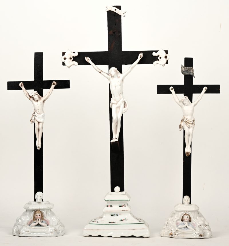 Drie kruisbeelden in porselein.