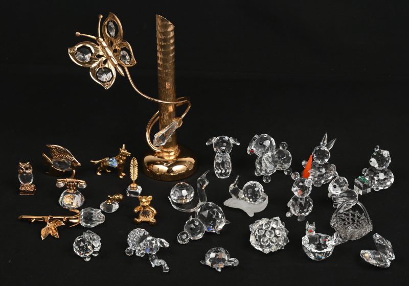 Een lot van vijftien diertjes van geslepen Swarovski-kristal. Bijgevoegd enkele andere kristallen voorwerpen en twee kleine presenteervitrines.