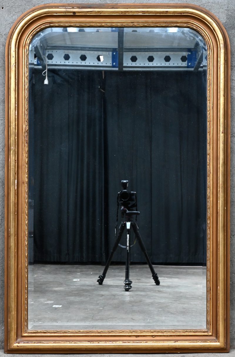 Een vergulde spiegel in Louis-Philippestijl.