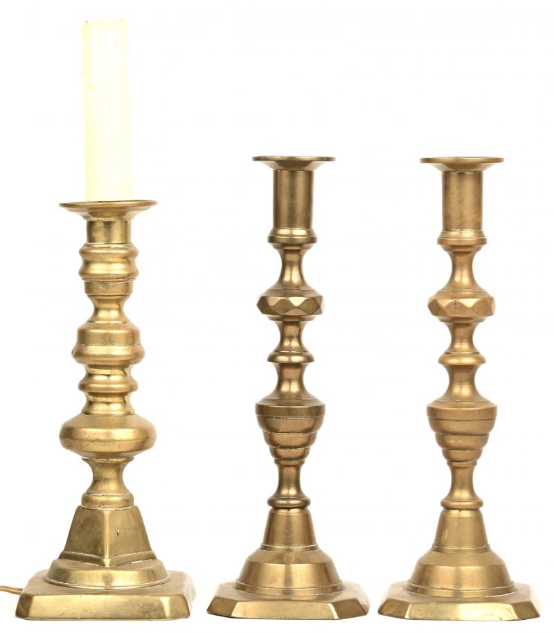 Een paar gotische kandelaars van gedraaid messing en een soortgelijke, gemonteerd als lamp.