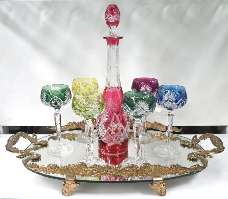 Een reeks van zes geslepen kristallen wijnglazen met gekleurde kelken met karaf en op spiegeldienblad.