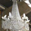Een kristallen sac-à-perles luchter met zes externe lichtpunten en twee bijpassende wandlichten (één interne spiegel manco). Lodewijk XVI-stijl.