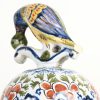 Een paar aardewerken dekselvazen met meerkleurige bloemendecors en de deksels getooid met vogels. Onderaan gemerkt. Frankrijk, eind XIX-eeuw. Eén staartje beschadigd.