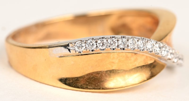Een 18 K wit en geelgouden ring bezet met briljanten met een gezamenlijk gewicht van +- 0,17 ct.