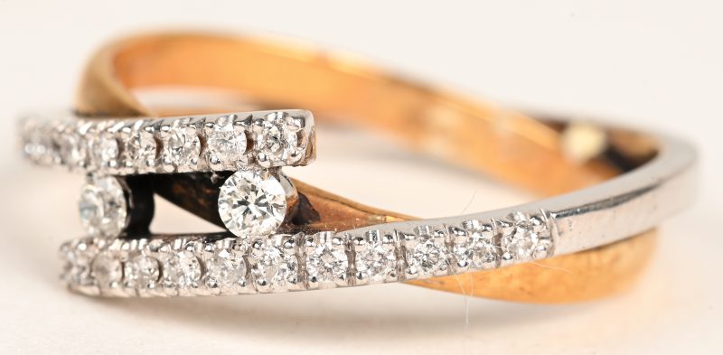 Een 18 K wit en geelgouden ring bezet met briljanten met een gezamenlijk gewicht van +- 0,31 ct.