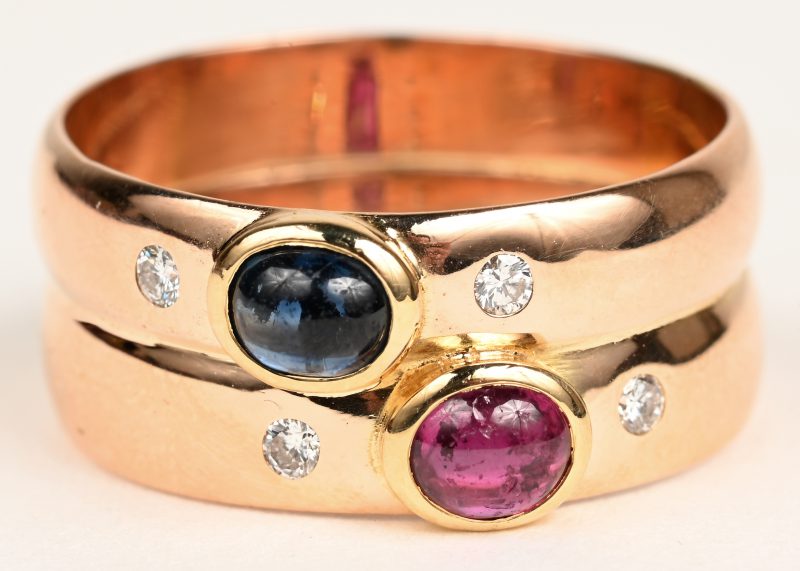 Een 18 K geelgouden ring bezet met twee briljantjes en een saffier en robijn cabochon met een gezamenlijk gewicht van +- 0,40 ct.