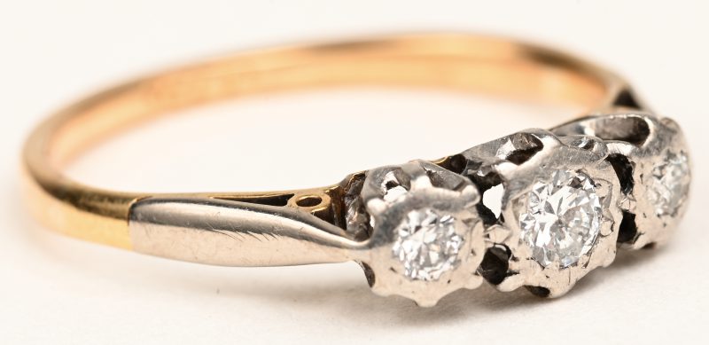 Een 18 K wit en geelgouden ring bezet met briljanten met een gezamenlijk gewicht van +- 0,10 ct.