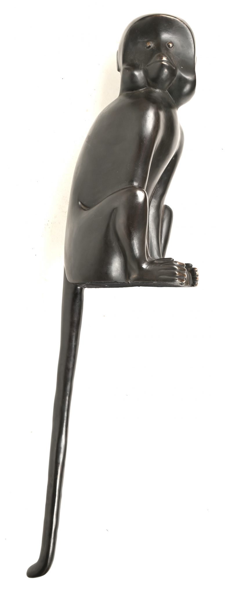 Een bronzen aap met een lange staart.