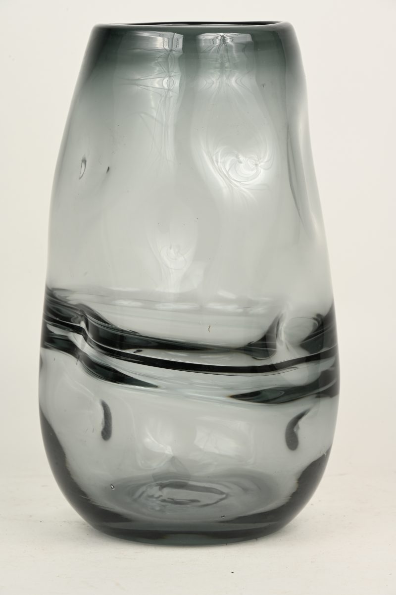 Een grijs getinte glazen vaas van bewogen vorm.