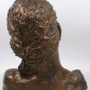 Een vrouwenbuste van terracotta met bronskleurig patina. Achteraan gesigneerd en gedateerd ‘88.