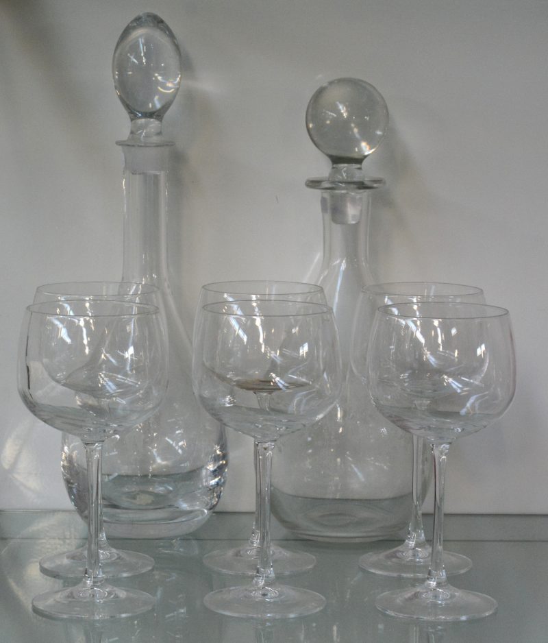 Twee karaffen van kleurloos glas met geslepen decors. Bijgevoegd zes kleurloze kristallen glazen van Cristal d’Arques.