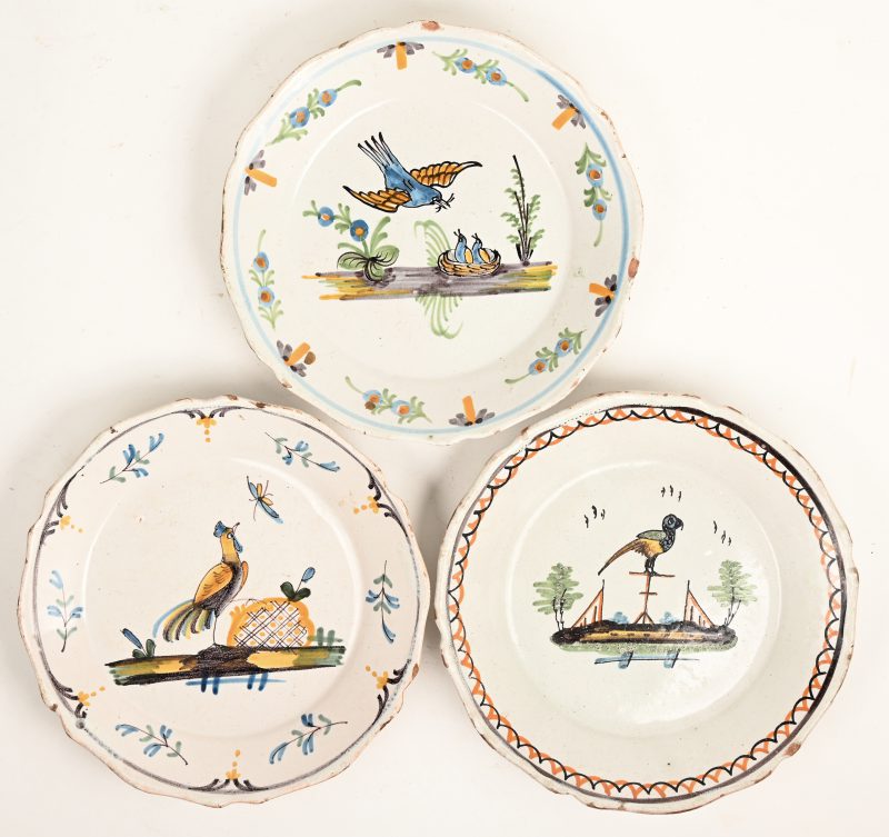Drie borden van Frans aardewerk met meerkleurige decors van vogels. XVIIIe eeuw. Lichte randschade.