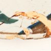Een grote aardewerken sierschotel met meerkleurig decor van vogels in een bloeiende struik. Achteraan gemerkt. Bijgevoegd twee borden met meerkleurige decors van bloemen en vogels, met meerdere beschadigingen. XVIIIe en XIXe eeuw.