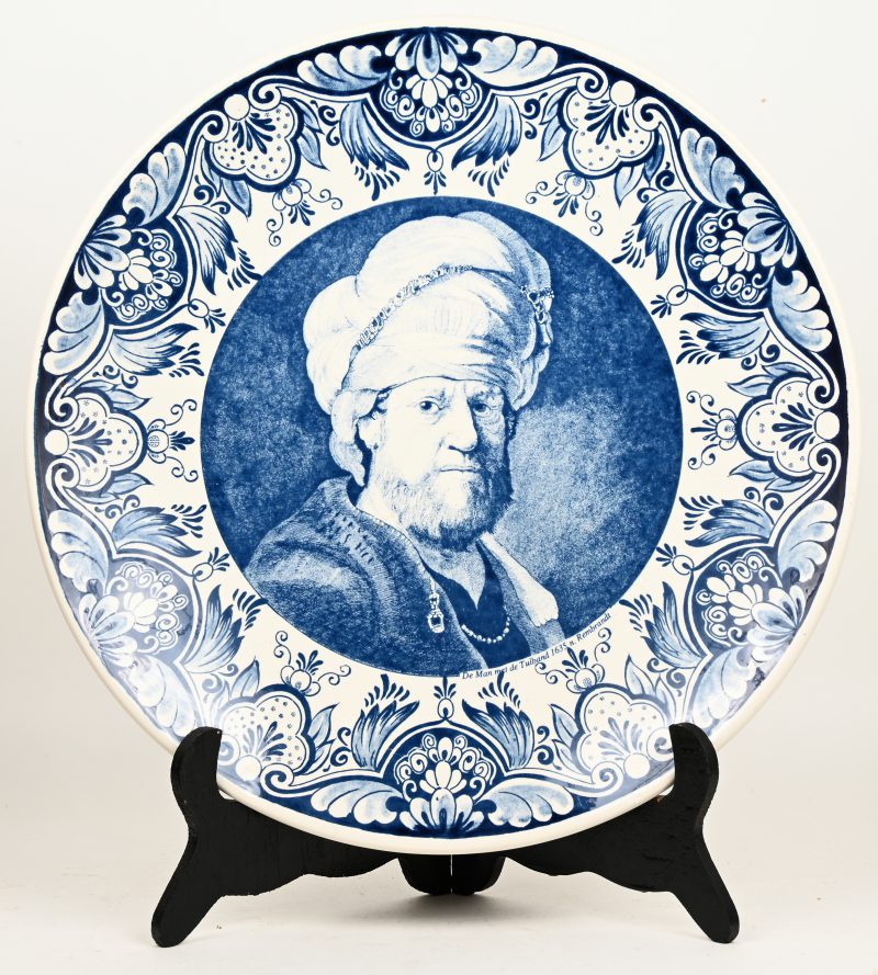 Een bord van Delfts plateel met een blauw-wit decor van “De man met de tulband” naar Rembrandt in het decor. Gemerkt. Minieme randschilfer.