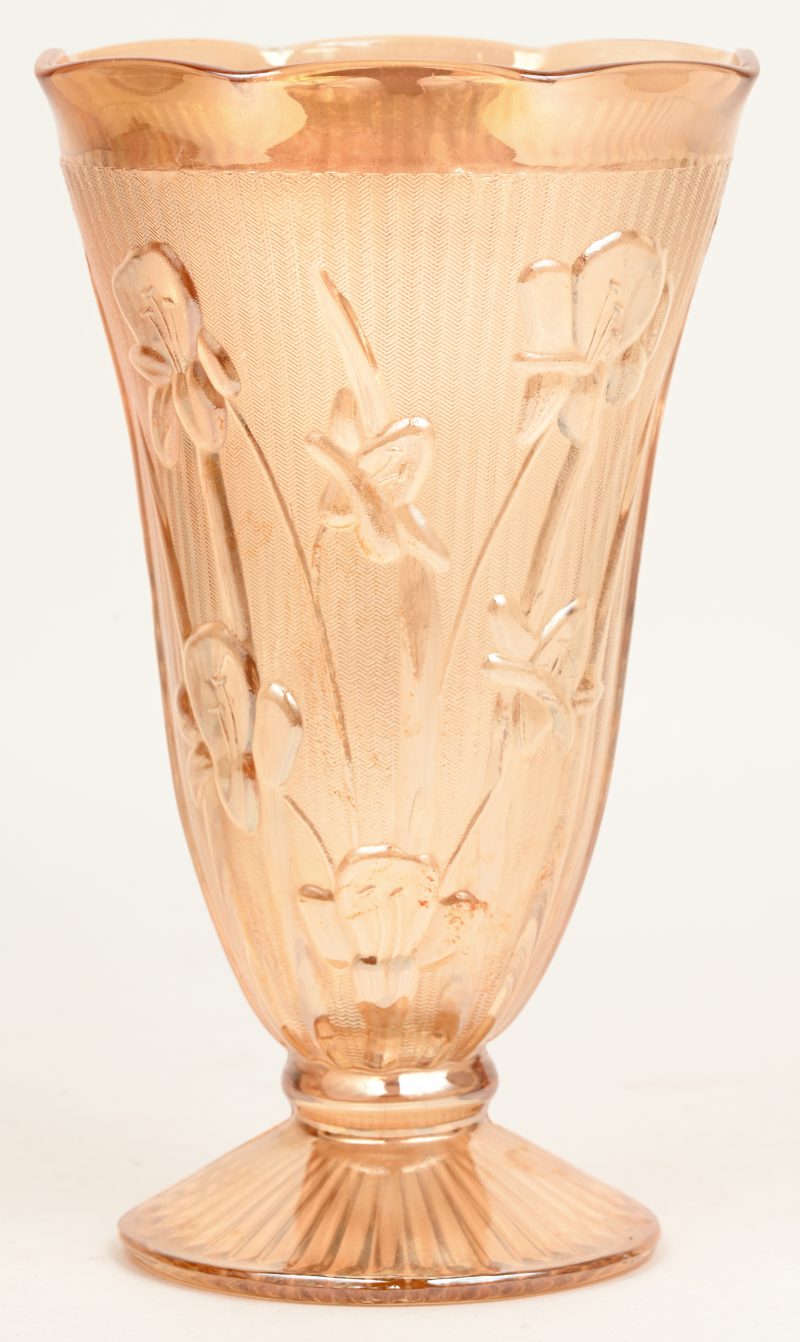 Een vaas van oud roze glas met decor van bloemen.