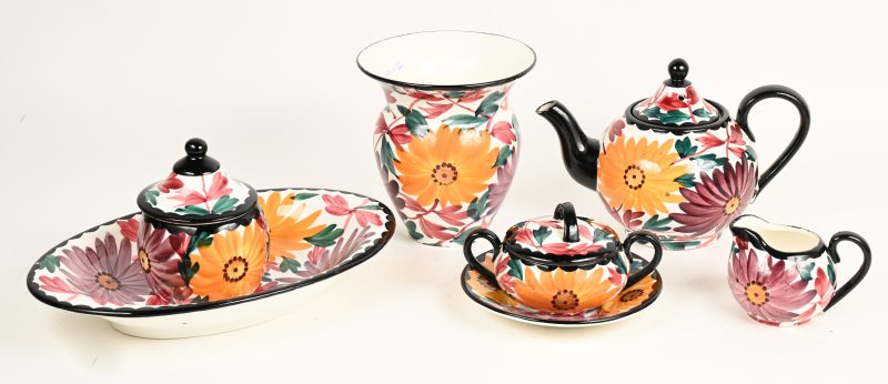 Een vierdelig aardewerken theestelletje met vaasje en schaaltje, alles versierd met handgeschilderd bloemendecor.