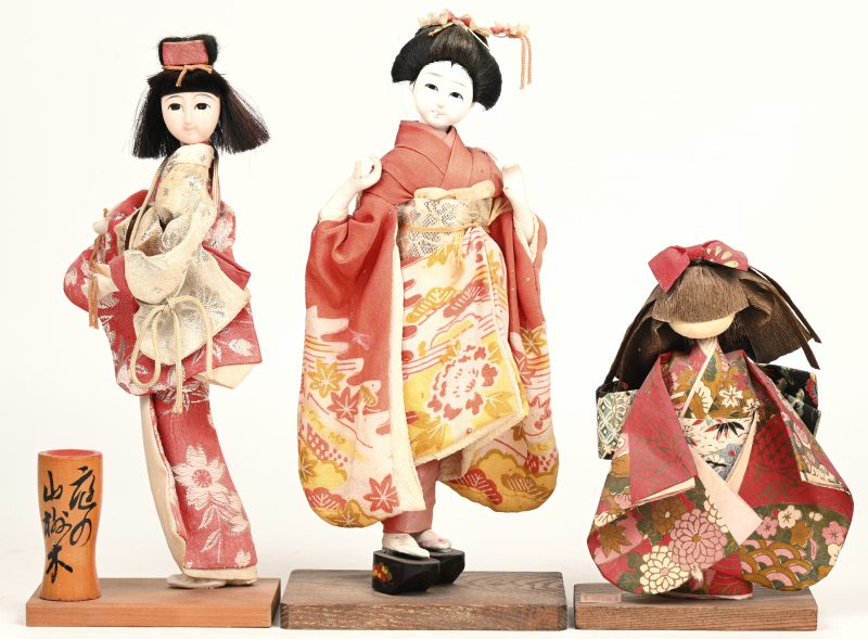 Drie verschillende Japanse geishapopjes op houten voetstukken. Japanse volkskunst.