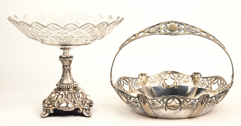 Een geslepen kristallen schotel op verzilverd metalen voet in barokke stijl. Enkele schilfers aan het glas. Bijgevoegd een verzilverd metalen mandje.