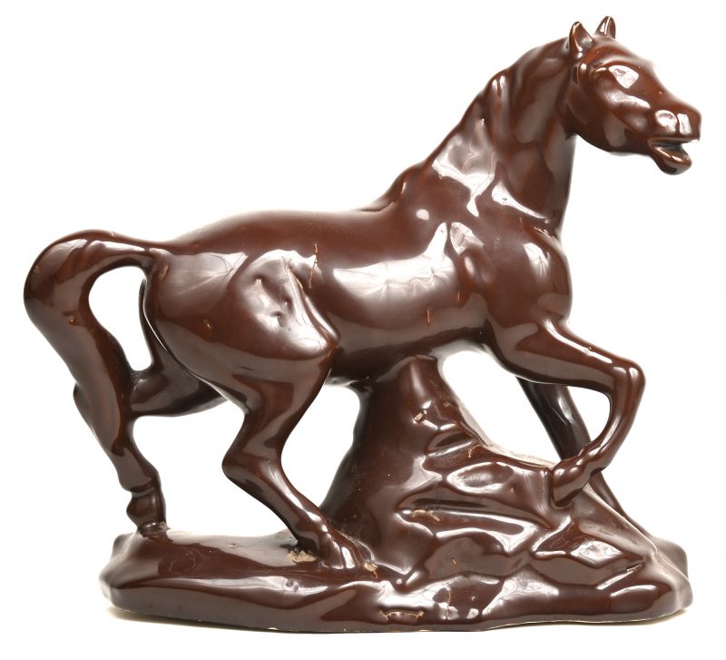 Een zwaar porseleinen paard met bruin glazuur.
